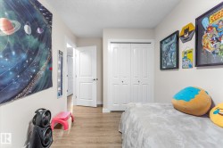Wood-finish flooring, white bi-fold closet doors, and a white interior door with a silver-tone handle - 