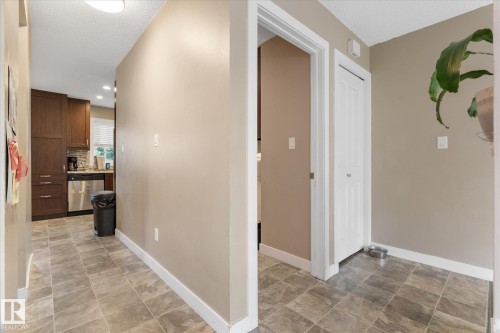 Kitchen with wood-finish cabinetry, stainless steel appliances, and tile flooring - 16012 98 Avenue Nw, Edmonton, AB 