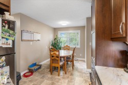 Kitchen featuring wood-finish cabinetry, light-toned countertops, and a stainless steel refrigerator - 