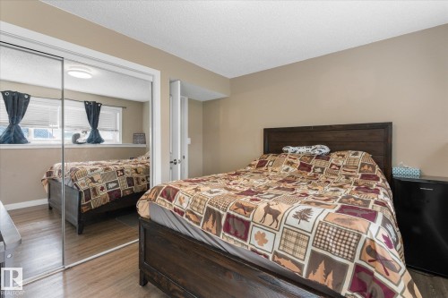Mirrored sliding closet doors, wood-finish flooring, and neutral wall paint - 16012 98 Avenue Nw, Edmonton, AB 
