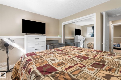 Neutral wall tones with white trim, wood-finish flooring, and mirrored closet doors - 16012 98 Avenue Nw, Edmonton, AB 