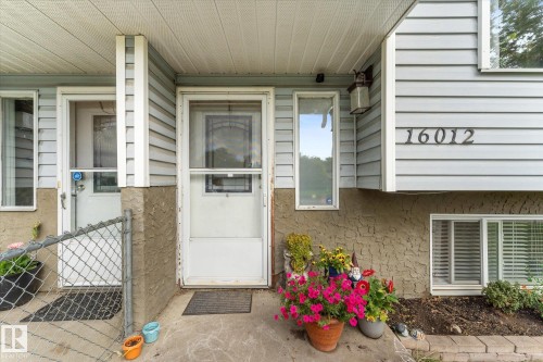 Light-colored siding exterior with a textured foundation - 16012 98 Avenue Nw, Edmonton, AB 