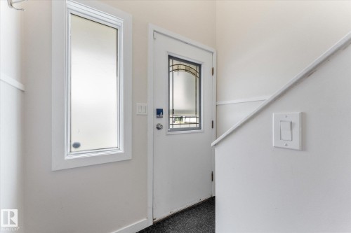 Entryway featuring a white door with decorative glass inserts, a frosted sidelight, and light gray wall paint - 16012 98 Avenue Nw, Edmonton, AB 