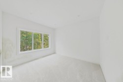 Bright interior space featuring a multi-pane window, recessed lighting, neutral carpeting, and white wall finishes - 