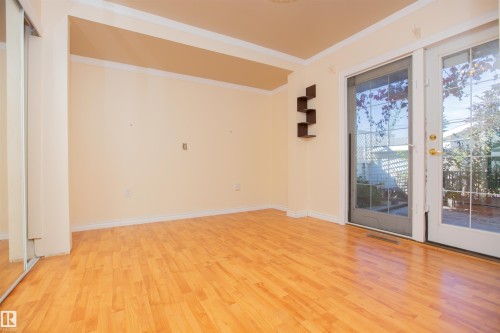 Wood-finish flooring, crown molding, and a sliding glass door with an exterior screen door - 13032 120 Street Nw, Edmonton, AB 