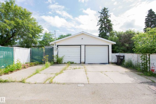 Detached garage featuring two garage doors and an asphalt shingle roof - 13032 120 Street Nw, Edmonton, AB 