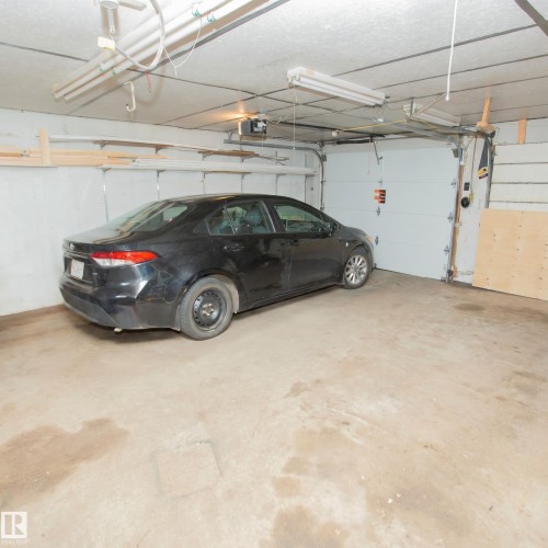Concrete flooring with overhead fluorescent lighting and an automatic garage door opener - 13032 120 Street Nw, Edmonton, AB 