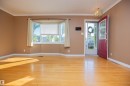 Hardwood flooring, bay window with window treatments, red entry door with glass inserts, and a decorative ceiling light fixture - 13032 120 Street Nw, Edmonton, AB 