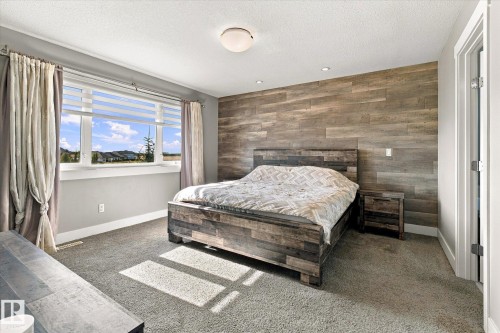 Accent wall featuring wood-look paneling, recessed lighting, and a neutral carpet - 2011 Genesis Lane, Stony Plain, AB 