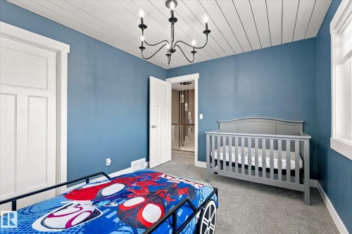 Shiplap ceiling with a black chandelier, blue painted walls, white trim, and light gray carpeting - 2011 Genesis Lane, Stony Plain, AB 