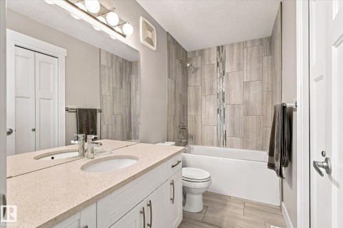 Dual sink vanity with light-colored countertop, white cabinetry, and brushed nickel hardware - 2011 Genesis Lane, Stony Plain, AB 