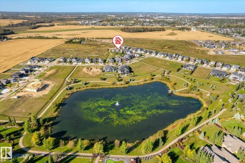 Manicured grounds with a water feature, paved walking paths, and surrounding mature landscaping - 2011 Genesis Lane, Stony Plain, AB 
