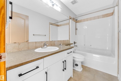Bathroom featuring a vanity with an integrated sink, broad countertop, and white cabinetry - 10621 175A Avenue Nw, Edmonton, AB 