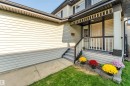 Inviting front entry featuring a covered porch, white paneled door, and dark trim - 10621 175A Avenue Nw, Edmonton, AB 