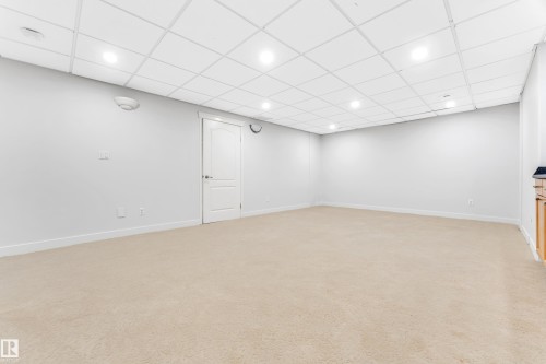 Spacious room featuring neutral carpeting, recessed lighting, and a drop ceiling - 10621 175A Avenue Nw, Edmonton, AB 