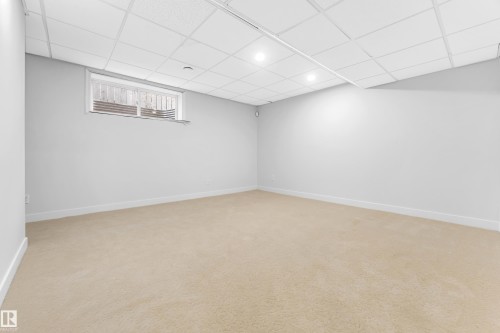 Finished room featuring light beige carpeting, white walls, and a drop ceiling with recessed lighting - 10621 175A Avenue Nw, Edmonton, AB 
