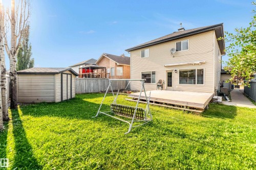 Expansive backyard featuring a manicured lawn, a detached storage shed, and mature trees - 10621 175A Avenue Nw, Edmonton, AB 