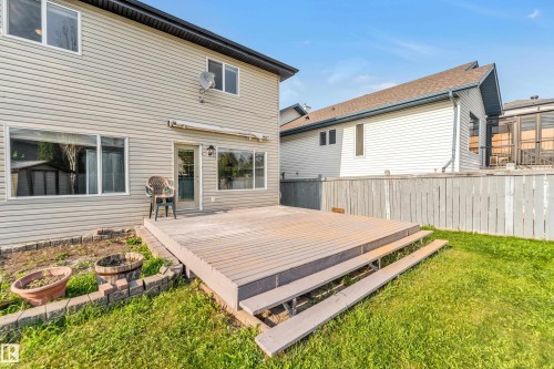 Rear yard featuring a multi-level composite deck, a privacy fence, and a grass lawn - 10621 175A Avenue Nw, Edmonton, AB 