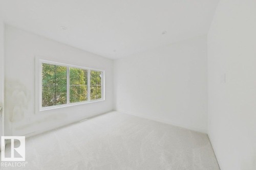Bright interior space featuring a multi-pane window, recessed lighting, neutral carpeting, and white wall finishes - 9216 91 Street Nw, Edmonton, AB - Indoor Photo Showing Other Room