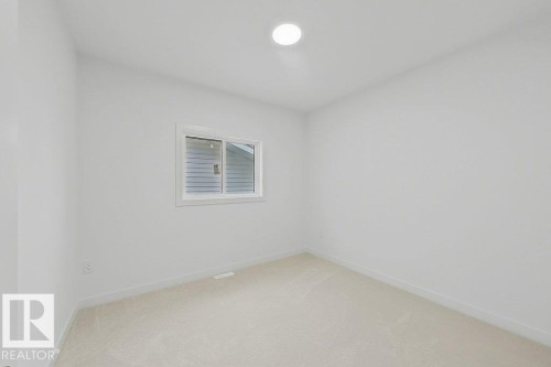 Neutral-toned carpeting complements the white walls and trim - 9216 91 Street Nw, Edmonton, AB - Indoor Photo Showing Other Room