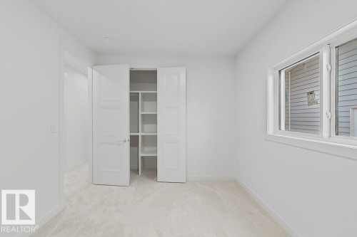 Bright room featuring white walls, white trim, and light carpeting - 9216 91 Street Nw, Edmonton, AB - Indoor Photo Showing Other Room