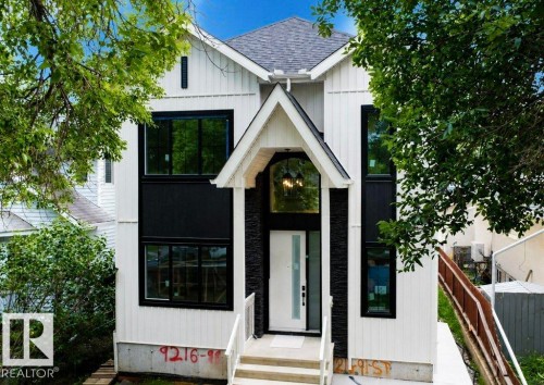 Modern facade featuring white vertical siding and black stone accents - 9216 91 Street Nw, Edmonton, AB - Outdoor