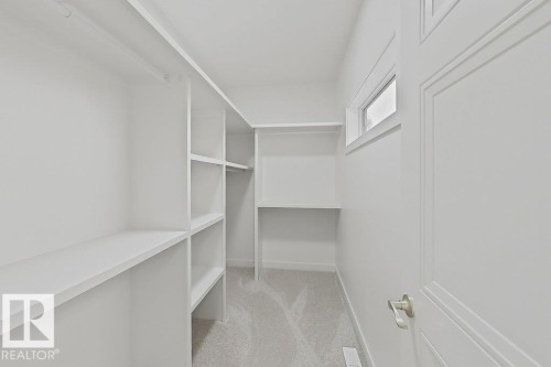 Walk-in closet featuring extensive built-in shelving, hanging rods, and a high-set window - 9216 91 Street Nw, Edmonton, AB - Indoor With Storage
