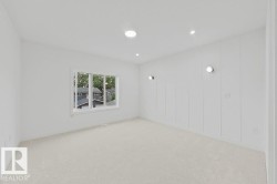 Spacious room with plush light-colored carpet and recessed ceiling lighting - 