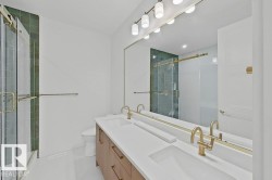 Double vanity with gold-tone hardware, white countertops, and wood-finish cabinetry - 