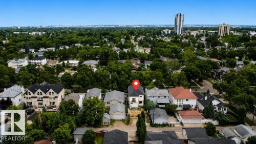 Aerial perspective showcasing a residential property with a multi-story structure and a detached garage, surrounded by mature trees - 9216 91 Street Nw, Edmonton, AB - Outdoor With View