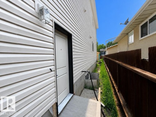 Side exterior with light-toned horizontal siding - 9216 91 Street Nw, Edmonton, AB - Outdoor With Exterior