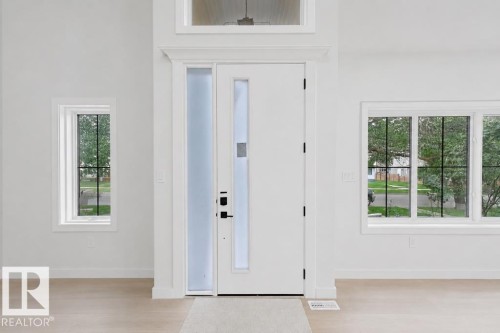 Bright entryway featuring a modern white door with a vertical glass insert, complemented by a tall frosted sidelight - 9216 91 Street Nw, Edmonton, AB - Indoor Photo Showing Other Room