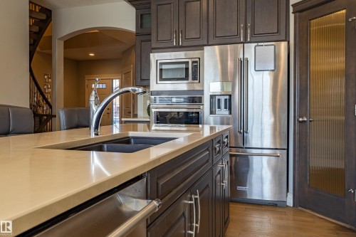 Kitchen island with a built-in double sink and chrome faucet - 233 Hawks Ridge Boulevard Nw, Edmonton, AB 