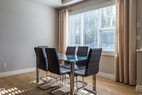 Wood-finish flooring, neutral wall tones, window with horizontal blinds, and a ceiling-mounted light fixture - 233 Hawks Ridge Boulevard Nw, Edmonton, AB 