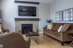 Stone-clad fireplace with a dark wood-finish mantel and integrated media area - 