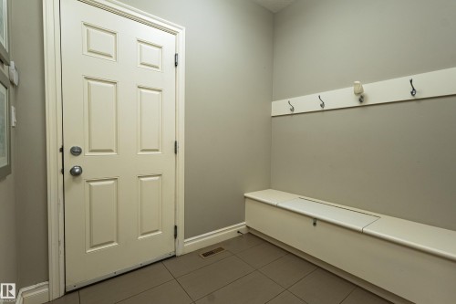 Panel door with chrome hardware, neutral wall color, and tile flooring - 233 Hawks Ridge Boulevard Nw, Edmonton, AB 