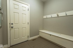 Panel door with chrome hardware, neutral wall color, and tile flooring - 