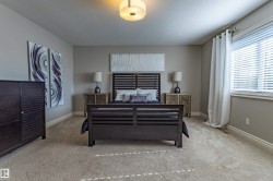 Neutral-toned walls, recessed lighting, and a window with blinds provide natural light - 