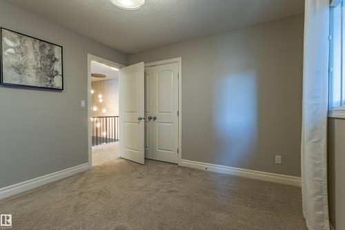 Neutral wall paint with white trim, carpeting, and a window with white window casing - 233 Hawks Ridge Boulevard Nw, Edmonton, AB 