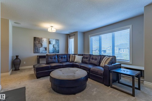 Recessed ceiling speaker, overhead semi-flush mount lighting, light gray wall paint, and a large window with blinds - 233 Hawks Ridge Boulevard Nw, Edmonton, AB 