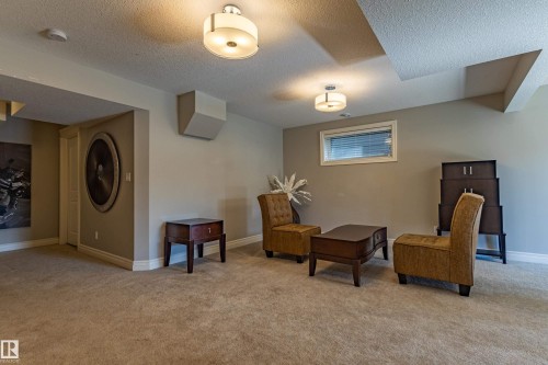 Recessed window, textured ceiling, two drum-style flush mount light fixtures, and wall-to-wall carpeting - 233 Hawks Ridge Boulevard Nw, Edmonton, AB 