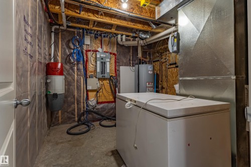 Central vacuum system, exposed ceiling joists, electrical panel, water heater, and utility sink - 233 Hawks Ridge Boulevard Nw, Edmonton, AB 