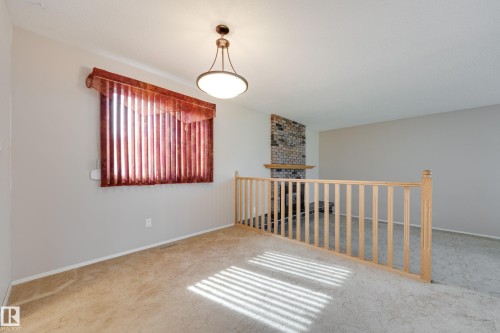 Carpeted flooring throughout, featuring a natural wood railing - 3421 135A Avenue Nw, Edmonton, AB 