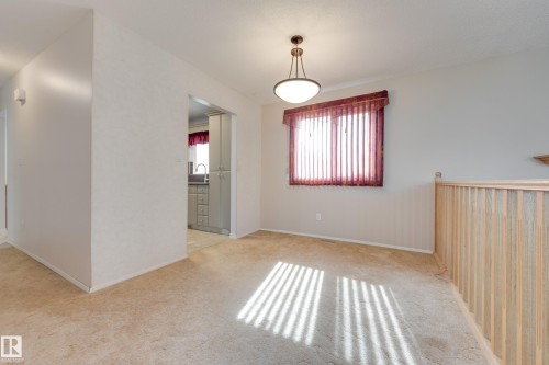 Recessed lighting, wood banister, window with vertical blinds, ceiling-mounted light fixture, and carpeting - 3421 135A Avenue Nw, Edmonton, AB 
