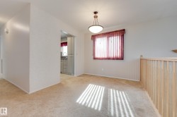 Recessed lighting, wood banister, window with vertical blinds, ceiling-mounted light fixture, and carpeting - 