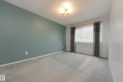 Carpeted flooring, window with blinds, wall-mounted light fixture, and a contrasting accent wall - 