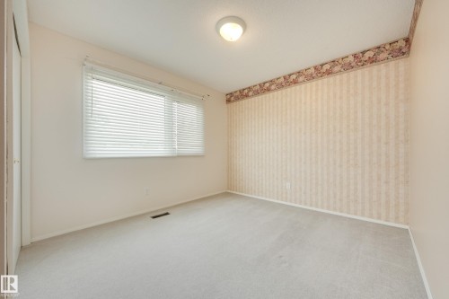 Wall-to-wall carpeting, window with horizontal blinds, wall-mounted light fixture, patterned wallpaper, and wall border - 3421 135A Avenue Nw, Edmonton, AB 