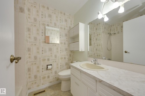 Single vanity with an integrated sink, broad wall mirror, and overhead track lighting - 3421 135A Avenue Nw, Edmonton, AB 