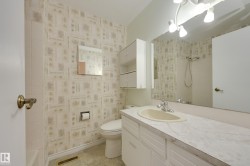 Single vanity with an integrated sink, broad wall mirror, and overhead track lighting - 