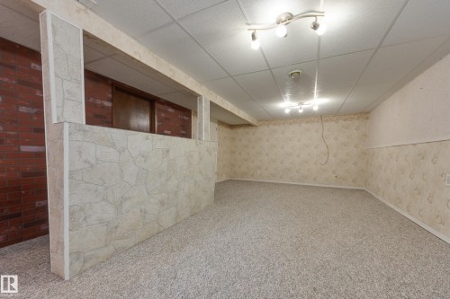 Recessed lighting fixtures illuminate a spacious area with carpet flooring and patterned wallpaper - 3421 135A Avenue Nw, Edmonton, AB 